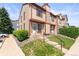 Inviting townhome with red and tan exterior, featuring a charming front entrance and well-maintained landscaping at 14465 E Hawaii Cir # A, Aurora, CO 80012