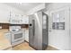 Kitchen with stainless steel refrigerator, white cabinets, and tiled backsplash and floors at 14465 E Hawaii Cir # A, Aurora, CO 80012