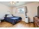 Comfortable bedroom with hardwood floors, a cozy bed, and a large window for natural light and a pleasant view at 5184 E Asbury Ave, Denver, CO 80222