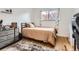 Bedroom with a warm ambiance, featuring hardwood floors, a comfy bed, and a serene atmosphere for relaxation at 5184 E Asbury Ave, Denver, CO 80222