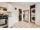 Modern kitchen featuring stainless steel appliances, tile backsplash, and a convenient in-unit washer and dryer at 5184 E Asbury Ave, Denver, CO 80222