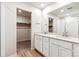 Bathroom featuring double sinks, cabinets, and open doorway to a closet at 19058 E 94Th Pl, Commerce City, CO 80022