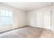 Bright bedroom featuring carpet, a window, and closet doors at 19058 E 94Th Pl, Commerce City, CO 80022
