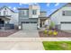 Two-story home featuring a two-car garage, modern architectural details, and manicured landscaping at 19058 E 94Th Pl, Commerce City, CO 80022