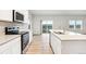 Modern kitchen with stainless appliances, white cabinetry, and a center island at 19058 E 94Th Pl, Commerce City, CO 80022