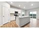 Open-concept kitchen features white cabinets, stainless appliances, an island, and access to a patio at 19058 E 94Th Pl, Commerce City, CO 80022