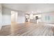 Open-concept living space with hardwood flooring flowing into the kitchen, stainless appliances, and island at 19058 E 94Th Pl, Commerce City, CO 80022