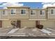 Townhouse exterior, featuring three garages and brick accents at 16058 E Geddes Ln # 26, Aurora, CO 80016