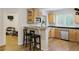 Bright kitchen with a bar counter, wood cabinets, stainless steel appliances, and wood-look flooring at 20363 E Top T Ranch Pl, Parker, CO 80134