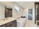 Modern bathroom boasts dual sinks, soaking tub, and large shower with dark accents at 3109 Newfound Lake Rd, Berthoud, CO 80513