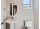 Bright half bathroom features modern pedestal sink and toilet with neutral tones at 3109 Newfound Lake Rd, Berthoud, CO 80513