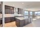 Modern kitchen with dark cabinets, stainless appliances, light wood floors, and a center island at 3109 Newfound Lake Rd, Berthoud, CO 80513