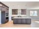 Modern kitchen boasts dark cabinets, stainless steel appliances and center island with white countertop at 3109 Newfound Lake Rd, Berthoud, CO 80513