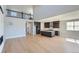 Open-concept living space with hardwood floors, a stone fireplace, and seamless access to the kitchen at 3109 Newfound Lake Rd, Berthoud, CO 80513