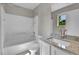 Bright bathroom featuring tiled tub/shower, granite vanity and a mirror with natural light coming through the window at 11803 W Tufts Pl, Morrison, CO 80465