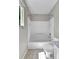 Clean bathroom features a tiled tub/shower, a toilet and a window providing natural light at 11803 W Tufts Pl, Morrison, CO 80465