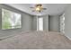 Inviting bedroom featuring plush carpet, neutral paint, ceiling fan and a large window for natural light at 11803 W Tufts Pl, Morrison, CO 80465