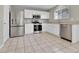 Modern kitchen with stainless steel appliances, granite countertops, white cabinets, and tile flooring at 11803 W Tufts Pl, Morrison, CO 80465