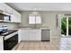 Bright kitchen features modern appliances, white cabinets, granite countertops, and a window at 11803 W Tufts Pl, Morrison, CO 80465