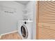 Bright laundry area with modern washer/dryer, wire shelving and a shuttered closet at 11803 W Tufts Pl, Morrison, CO 80465