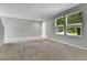 Inviting living room with plush carpet, neutral paint, and natural light from large windows, creating a cozy space at 11803 W Tufts Pl, Morrison, CO 80465