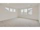 Expansive bedroom with plush carpeting and abundant natural light from the numerous large windows at 661 Sunrise St, Erie, CO 80516