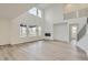 Open concept living room boasting soaring ceilings, large windows, a modern fireplace, and light wood floors at 661 Sunrise St, Erie, CO 80516