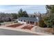 An aerial view of a single-story house with a well-manicured yard, mature trees, and a peaceful neighborhood setting at 391 Burgess Dr, Castle Rock, CO 80104