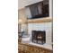 Close-up of the fireplace featuring white tile, a wooden mantel, and a decorative fire screen at 391 Burgess Dr, Castle Rock, CO 80104