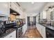 Modern kitchen with white cabinets, granite countertops, stainless steel appliances, and wood flooring at 391 Burgess Dr, Castle Rock, CO 80104