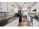 Well-lit kitchen featuring white cabinets, black countertops, and stainless-steel appliances at 391 Burgess Dr, Castle Rock, CO 80104