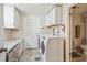 Bright laundry room with white washer and dryer, storage, and access to a small bathroom at 391 Burgess Dr, Castle Rock, CO 80104