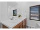 Contemporary bathroom with double sinks, wood cabinets, and a large mirror at 10157 W Fremont Pl, Littleton, CO 80127