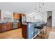 Eat-in kitchen with stainless steel appliances, wood cabinets, counter seating and pendant lighting at 10157 W Fremont Pl, Littleton, CO 80127