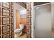 Retro bathroom features square patterned wallpaper, a shower, and a white toilet at 2909 S Zurich Ct, Denver, CO 80236