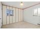 Sunny bedroom with two windows, neutral carpet, decorative wall covering, and bright natural light at 2909 S Zurich Ct, Denver, CO 80236