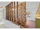 Charming living room showcasing a decorative brick accent wall and wood railing at 2909 S Zurich Ct, Denver, CO 80236