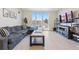 Bright living room featuring a large sofa, modern media console, and expansive windows with neighborhood views at 5125 W 29Th Ave # 5, Denver, CO 80212