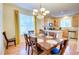 Dining room with wood floors, a stylish table, and a view into the modern kitchen at 10550 Ashfield St, Highlands Ranch, CO 80126