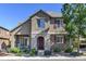 Charming two-story home featuring a stone-accented entrance and covered patio, surrounded by lush landscaping at 10550 Ashfield St, Highlands Ranch, CO 80126