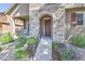 Inviting front porch with stone archway, manicured landscaping, and cozy seating at 10550 Ashfield St, Highlands Ranch, CO 80126