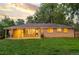 A charming brick house with a well-maintained lawn and covered patio at dusk at 2391 S Quitman St, Denver, CO 80219