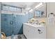Renovated bathroom featuring blue tile, modern fixtures, and double sinks at 2391 S Quitman St, Denver, CO 80219