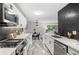 Modern kitchen featuring stainless steel appliances, white cabinets, and unique backsplash at 2391 S Quitman St, Denver, CO 80219