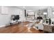 Open-concept living room with hardwood floors, modern decor, and seamless flow to the dining area at 2391 S Quitman St, Denver, CO 80219