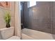 Stylish bathroom showcasing dark gray tiled walls, a white bathtub with shower curtain and decorative art at 1534 Irving St, Denver, CO 80204