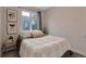 Cozy bedroom featuring a comfortable bed, simple decor, and a large window with natural light at 1534 Irving St, Denver, CO 80204
