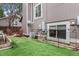 Cozy backyard with artificial turf, fencing, and red rocking chairs next to the exterior of the home at 3852 S Genoa Ct # B, Aurora, CO 80013