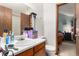 Functional bathroom featuring a vanity with storage, a toilet, and a mirror with a light fixture at 3852 S Genoa Ct # B, Aurora, CO 80013