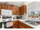Functional kitchen with wood cabinets, white countertops, and essential appliances including a stove and microwave at 3852 S Genoa Ct # B, Aurora, CO 80013